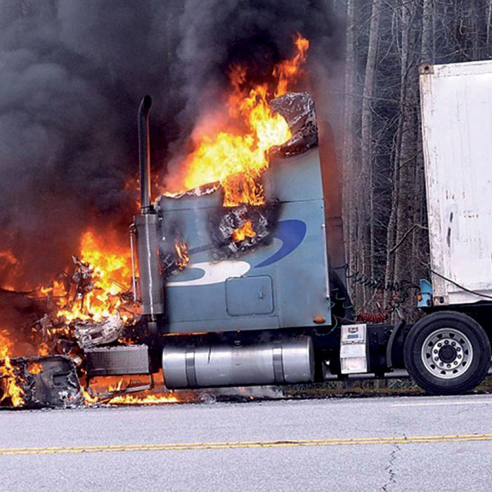 semi truck on fire with smoke on the side of the highway