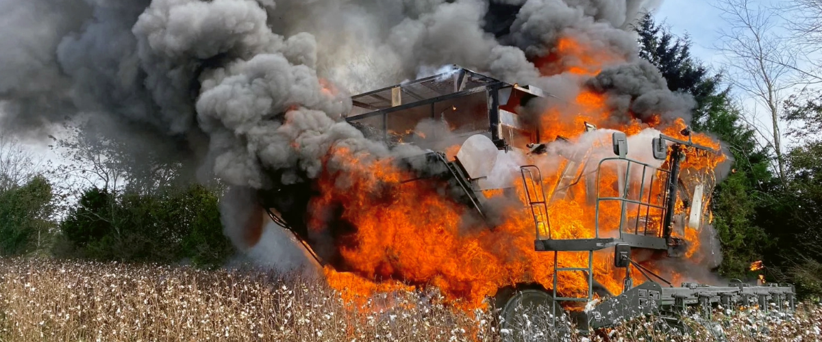 Cotton Stripper harvesting with flames and smoke coming from it