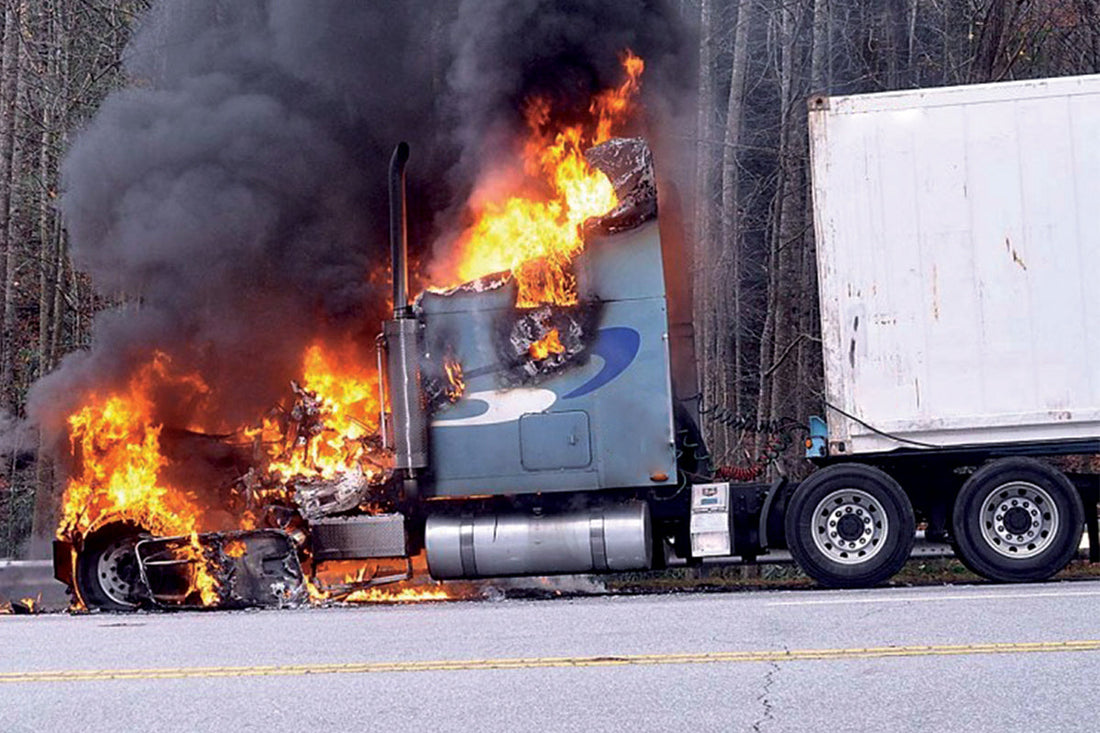 semi truck on fire with smoke on the side of the highway