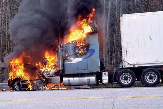 semi truck on fire with smoke on the side of the highway